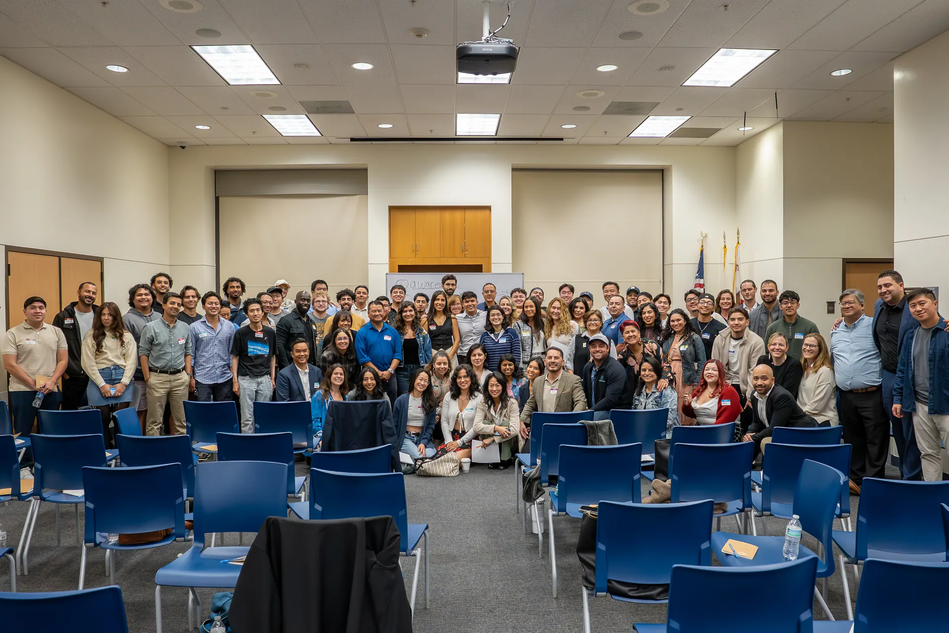 Eliam with a full room of attendees after a leadership event